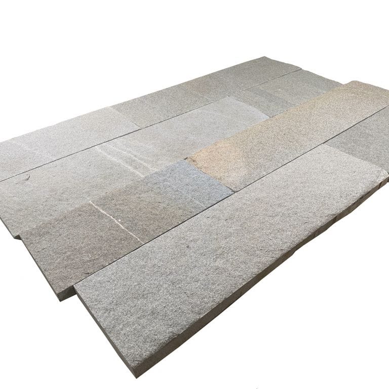 Oblique image for Heritage Plank Granite - Buff - Plank Pavers. The surface finish shown is split-face. The dominant color shown is gray. The color mix creates a warm feeling.