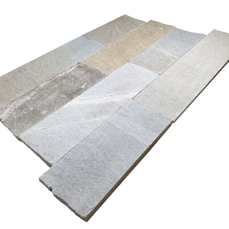 Oblique image for Heritage Plank Granite - Full Color - Planks. The surface finish shown is split-face. Dominant colors shown are gray and greige. The color mix creates a warm feeling.
