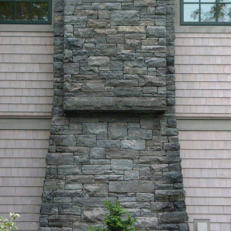 Application image for Granite - Mystic Mountain- Splitface Veneer. The image shows this product being used in a full bed veneer application. The surface finish shown is split-face. Dominant colors shown are green and gray. Exhibits "movement" and the color mix creates a cool feeling. Regular and linear color patterns.