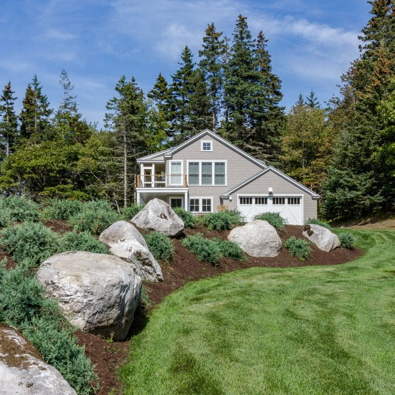 Application image for New England Fieldstone - Boulders. The image shows this product being used in a landscape boulders &amp; ledge application. The surface finish shown is weathered. The dominant color shown is gray. The color mix creates a cool feeling.