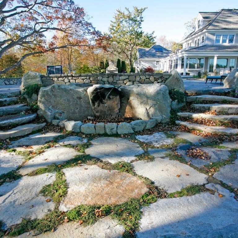 Application image for New England Fieldstone - Natural Surface Irregular Pavers. The image shows this product being used in a patio pavers application. The surface finish shown is natural cleft. The dominant color shown is gray.