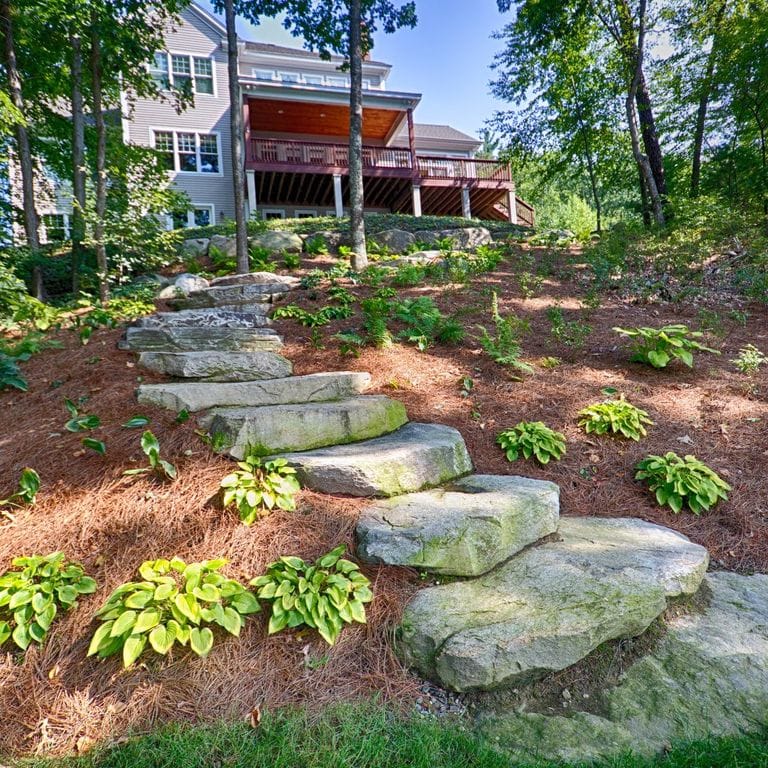 Application image for New England Fieldstone - Steps and Landings. The image shows this product being used in a monolithic steps application. This is a landscape stone for outdoor commercial and residential applications. Suitable for general use, freeze-thaw conditions, high traffic areas and low slipperiness surfaces situations. Moderate to higher on the price spectrum.