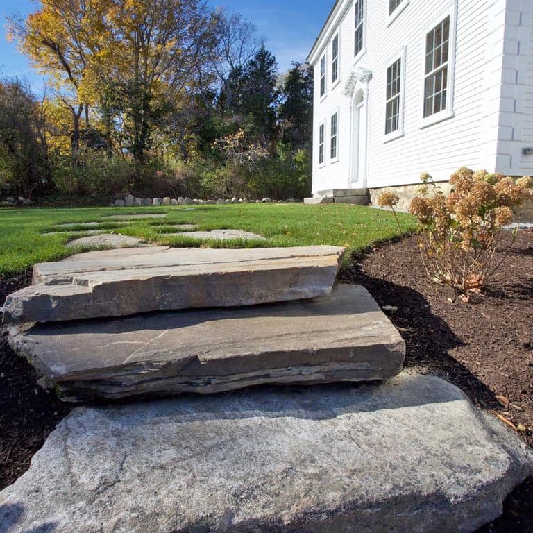 Application image for New England Fieldstone - Steps and Landings. The image shows this product being used in a monolithic steps application. This is a landscape stone for outdoor commercial and residential applications. Suitable for general use, freeze-thaw conditions, high traffic areas and low slipperiness surfaces situations. Moderate to higher on the price spectrum.