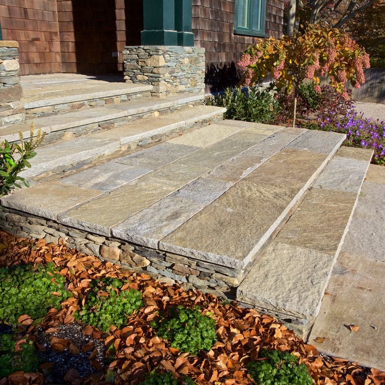 Feature image for Reclaimed Granite Plank Pavers - Sawn Edge. The image shows this product being used for landings and treads. Dominant colors shown are beige, brown, gray and tan; with a cream secondary. Exhibits "movement" and the color mix creates a warm feeling. Fine speckled, blotched, random and cloudy color patterns.