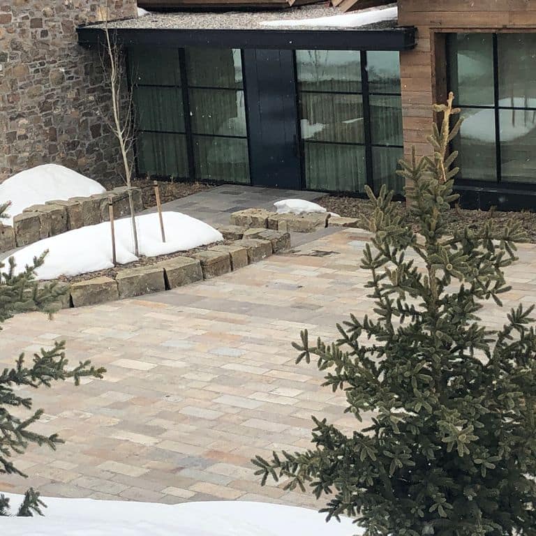 Application image for Reclaimed Footworn Granite Plank Pavers. The image shows this product being used in a patio pavers application. The surface finish shown is . Dominant colors shown are beige, gray and tan. The color mix creates a warm feeling. Regular and speckled color patterns.