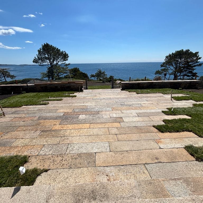 Application image for Reclaimed Footworn Granite - Plank Pavers. The image shows this product being used in a patio pavers application. The surface finish shown is . Dominant colors shown are beige and gray; with beige, white and tan secondaries. Speckled color pattern.
