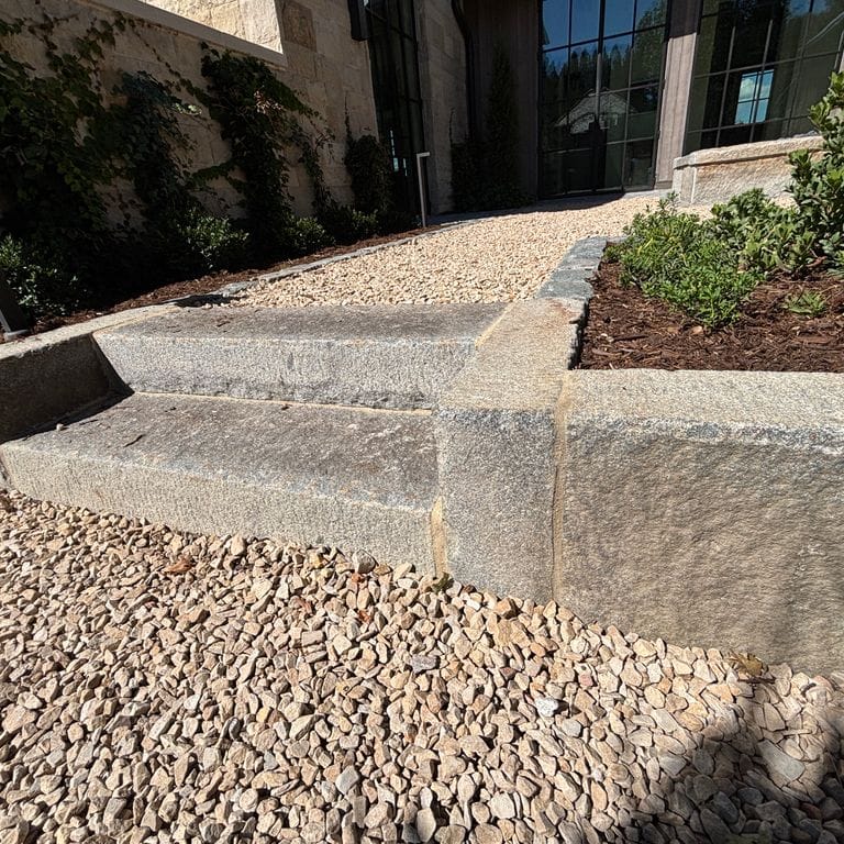 Application image for Reclaimed First Generation Curbstone - Textured Riser and Tread Steps. The image shows this product being used in a treads application. The surface finish shown is . The dominant color shown is gray. The color mix creates a warm feeling.