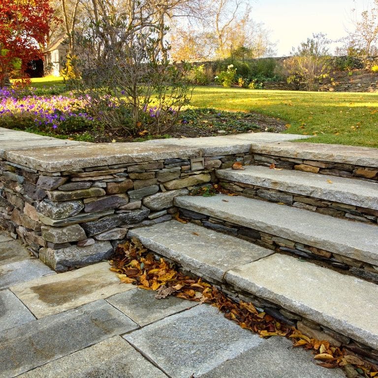 Application image for Reclaimed Granite Treads - Weathered Riser and Tread. The image shows this product being used in a treads application. This is a landscape stone for indoor and outdoor commercial and residential applications. Suitable for general use, freeze-thaw conditions, low heat absorption surfaces, high traffic areas, low slipperiness surfaces and high heel compatibilty situations. Higher to high on the price spectrum.