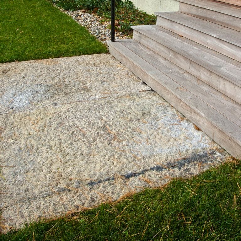 Close-up image for Reclaimed Granite Landings. The surface finishes shown are split-face with flat plane, weathered and worn. Dominant colors shown are beige and gray; with brown, orange/rust, white, tan and cream secondaries. The color mix creates a warm feeling. Random, speckled and blotched color patterns.