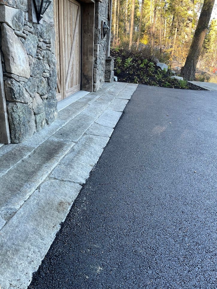 Application image for Reclaimed Granite Curbstone - Driveway Apron. The image shows this product being used in a driveway aprons application. The surface finish shown is . Dominant colors shown are blue and gray. The color mix creates a cool feeling.