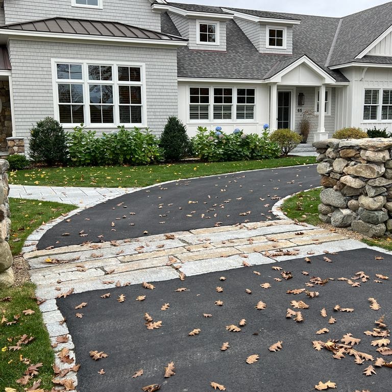 Application image for Reclaimed Granite Curbstone - Driveway Apron. The image shows this product being used in a driveway aprons application. Dominant colors shown are beige, gray, white and cream. The color mix creates a warm feeling.