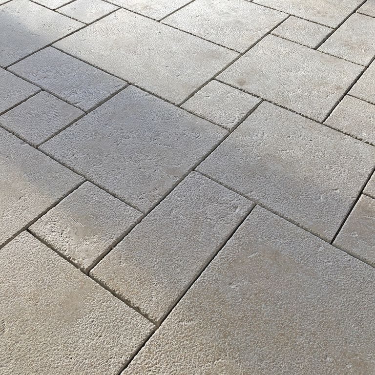 Application image for Limestone - Mountain Hard Beige - Dimensional Cut Pavers. The image shows this product being used in a patio pavers application. Dominant colors shown are gray and cream; with beige, white and tan secondaries. Solid and speckled color patterns.