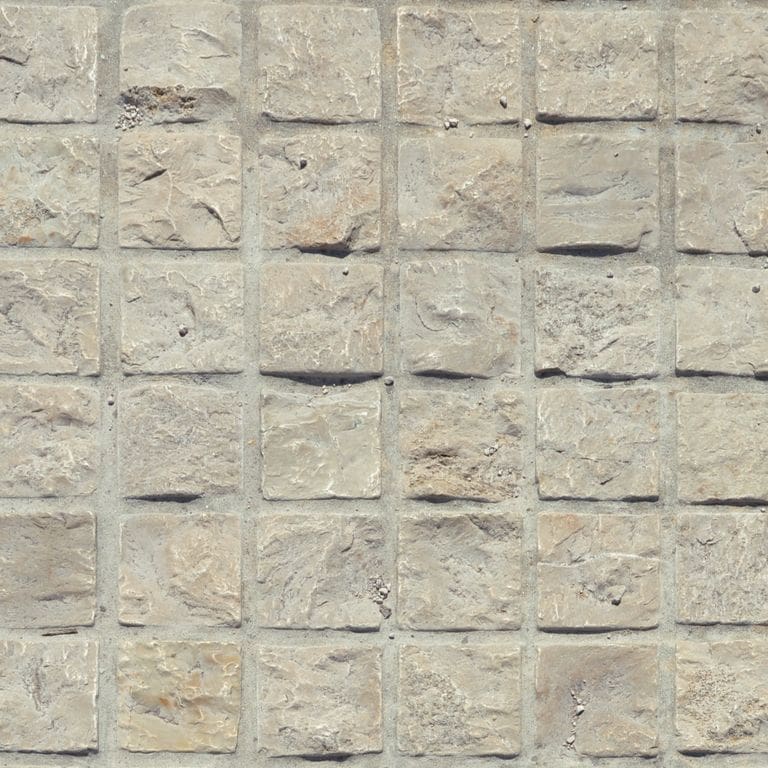 Close-up image for Mountain Hard Limestone Beige - Cobblestone Pavers. The surface finish shown is split-face with rough plane. Dominant colors shown are beige and gray; with tan and cream secondaries. Exhibits "movement" and the color mix creates a warm feeling. Regular, blotched and cloudy color patterns.