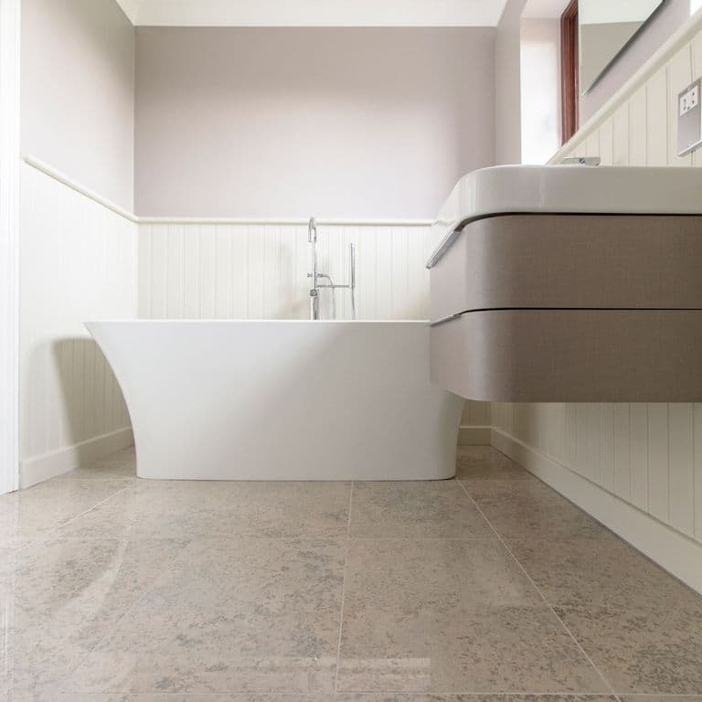 Feature image for Mountain Hard Limestone Blue - Interior Flooring. The image shows this product being used in an interior floor application. Dominant colors shown are gray and tan; with beige, brown, purple and white secondaries. Exhibits "movement" and the color mix creates a warm feeling. Blotched color pattern.
