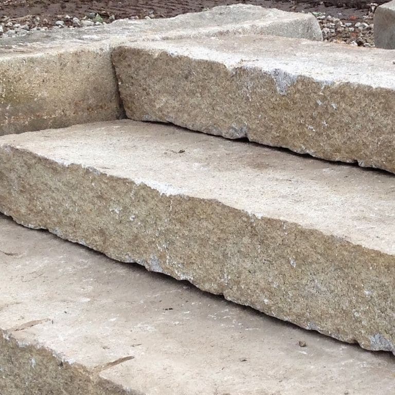 Application image for Reclaimed Second Generation Granite Curbstone Steps - Split Face Riser. The image shows this product being used in a monolithic steps application. This is a landscape stone for outdoor commercial and residential applications. Suitable for general use, freeze-thaw conditions, low heat absorption surfaces, high traffic areas and low slipperiness surfaces situations. Higher to high on the price spectrum.