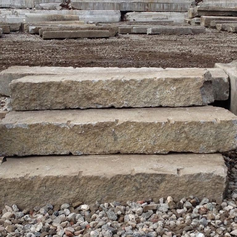Application image for Reclaimed Second Generation Granite Curbstone Steps - Split Face Riser. The image shows this product being used in a monolithic steps application. This is a landscape stone for outdoor commercial and residential applications. Suitable for general use, freeze-thaw conditions, low heat absorption surfaces, high traffic areas and low slipperiness surfaces situations. Higher to high on the price spectrum.