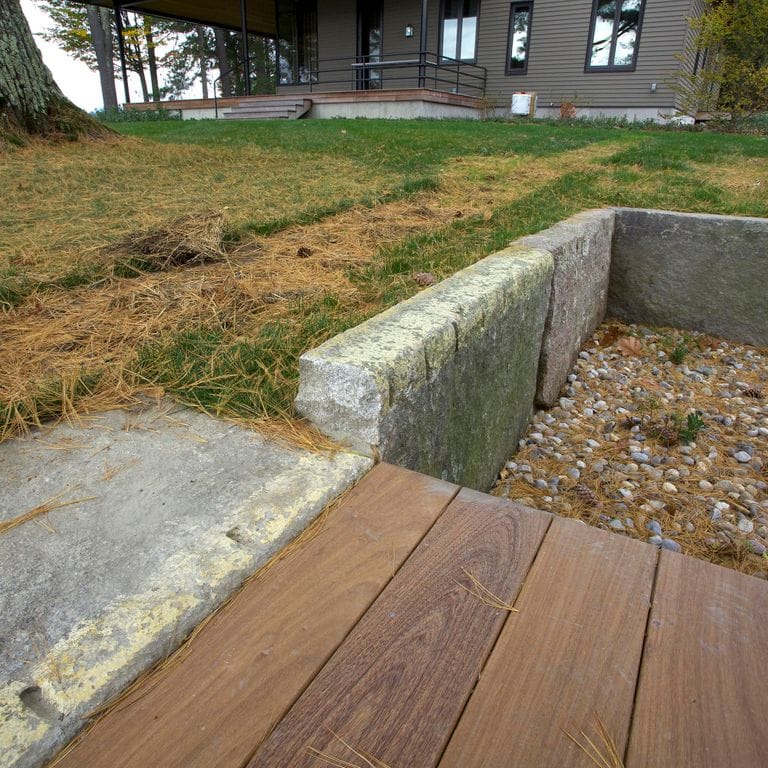 Application image for Reclaimed First Generation Granite Curbstone Edging. The image shows this product being used in a landscape curbing &amp; edging application. This is a landscape stone for outdoor commercial and residential applications. Suitable for general use, freeze-thaw conditions, low heat absorption surfaces, high traffic areas, low slipperiness surfaces and high heel compatibilty situations. Higher to high on the price spectrum.