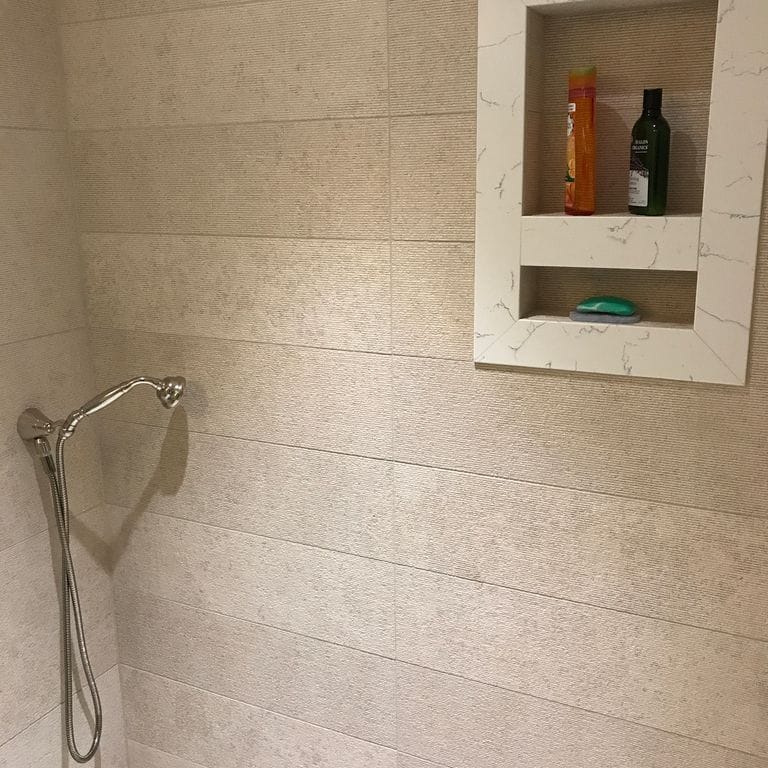 Application image for Mountain Hard Limestone Beige - Wall Veneer. The image shows this product being used in a bath tub &amp; shower application. This is a building stone for indoor and outdoor commercial and residential applications. Suitable for general use, freeze-thaw conditions, low heat absorption surfaces, high traffic areas, low slipperiness surfaces and high heel compatibilty situations. Moderate to high on the price spectrum.