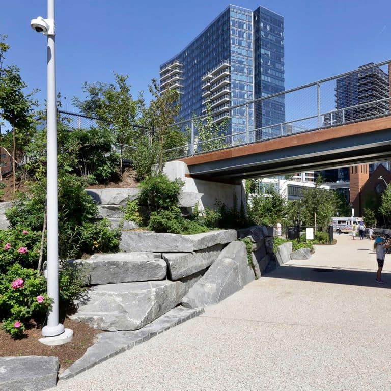 Application image for Granite - Reclaimed New England Quarry Tailings - Oversized Wallstone. The image shows this product being used in a landscape wallstone application. The dominant color shown is gray. The color mix creates a cool feeling.