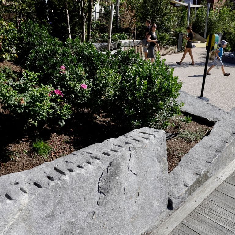 Application image for Granite - Reclaimed New England Quarry Tailings - Oversized Wallstone. The image shows this product being used in a landscape wallstone application. The dominant color shown is gray. The color mix creates a warm feeling.