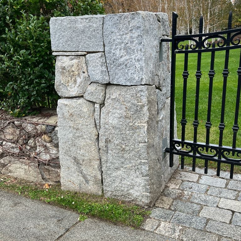 Application image for Granite - Reclaimed New England Quarry Tailings - Oversized Wallstone. The image shows this product being used in a landscape wallstone application. The dominant color shown is gray.