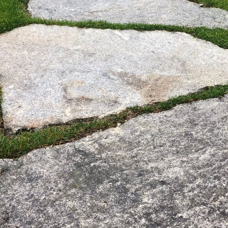 Close-up image for Reclaimed New England Granite Quarry Tailings - Oversized Pavers. The surface finishes shown are split-face with flat plane and weathered. The dominant color shown is gray; with beige, black, brown, pink, purple, white and cream secondaries. Exhibits "movement" and the color mix creates a cool feeling. Random, speckled, blotched, streaked and cloudy color patterns.