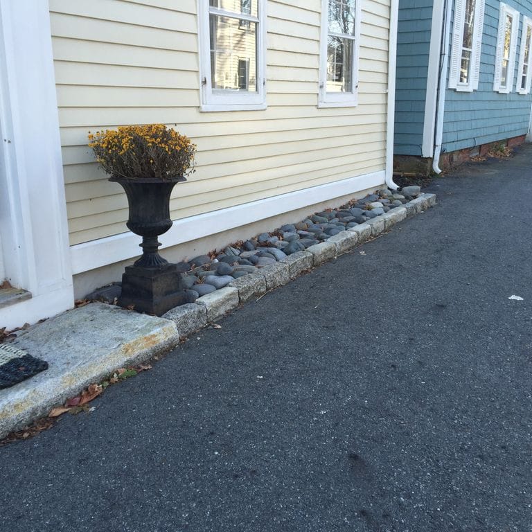 Application image for Reclaimed New England Granite Cobblestones - Jumbo Edging. The image shows this product being used in a landscape curbing &amp; edging application. This is a landscape stone for outdoor commercial and residential applications. Suitable for general use, freeze-thaw conditions, low heat absorption surfaces, high traffic areas and low slipperiness surfaces situations. Relatively moderate in price.