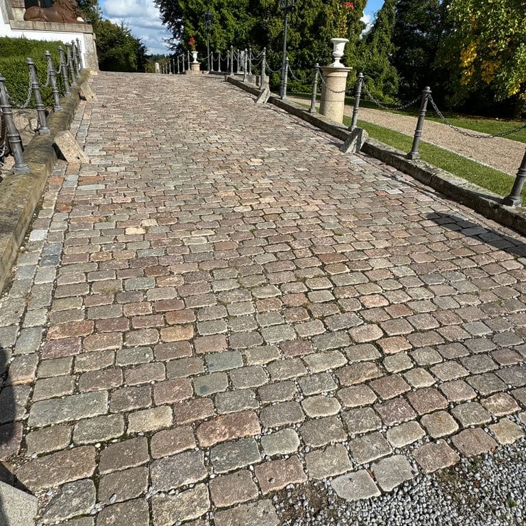 Application image for Reclaimed Swedish Granite Cobblestones - Worn Surface. The image shows this product being used in a path pavers application. The surface finish shown is . The dominant color shown is gray. The color mix creates a warm feeling.