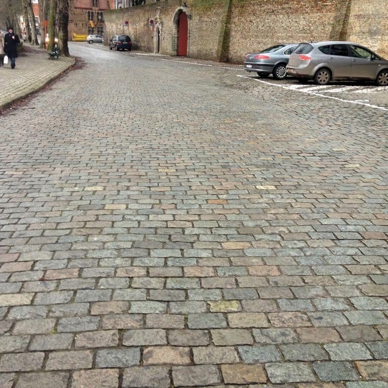 Application image for Reclaimed European Porphyry Cobblestones - Rectangle - Worn. The image shows this product being used in a driveway pavers application. The surface finish shown is . The dominant color shown is gray. The color mix creates a warm feeling.