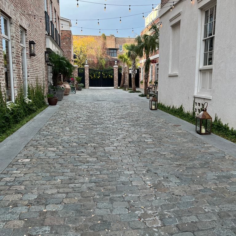 Application image for Reclaimed European Porphyry Cobblestones - Rectangle - Worn. The image shows this product being used in a path pavers application. The surface finish shown is . The dominant color shown is gray.