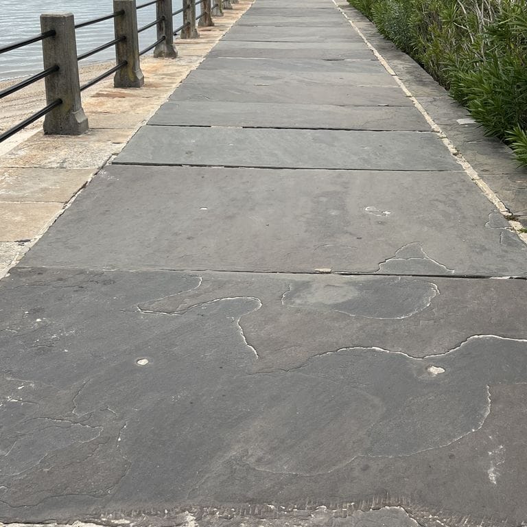 Application image for Reclaimed Bluestone Sidewalk Stones. The image shows this product being used in a path pavers application. The surface finish shown is natural cleft. The dominant color shown is gray. The color mix creates a warm feeling.