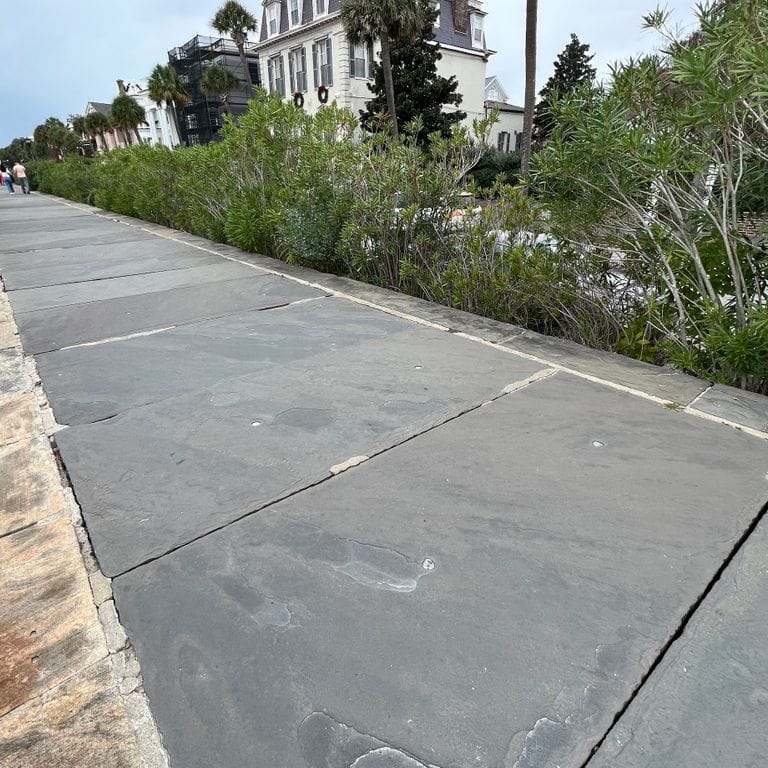 Application image for Reclaimed Bluestone Sidewalk Stones. The image shows this product being used for path pavers and public area. The surface finish shown is natural cleft. The dominant color shown is gray. The color mix creates a cool feeling.