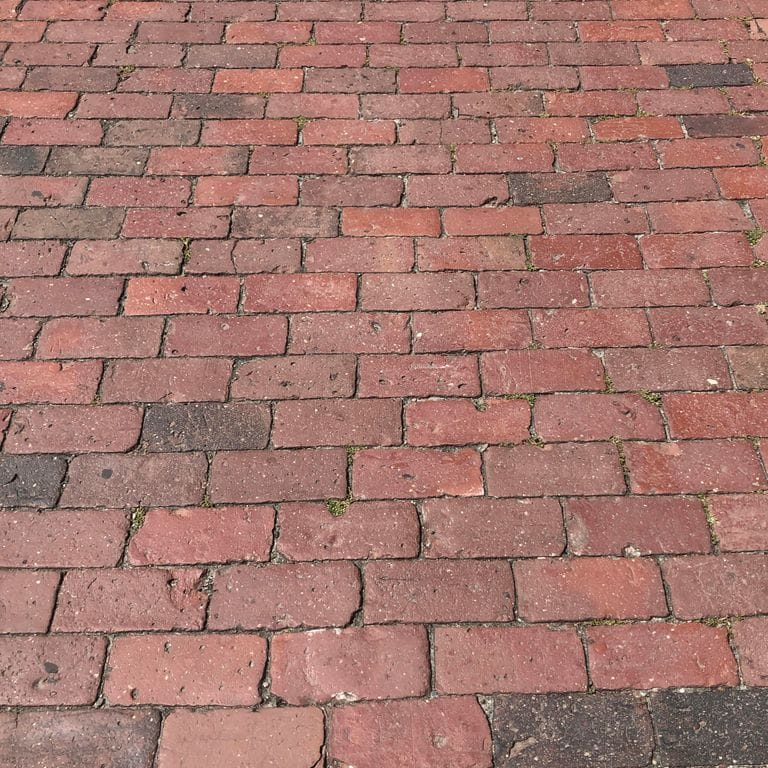 Application image for Reclaimed Boston Brick Pavers. The image shows this product being used for driveway pavers and patio pavers. The dominant color shown is red. The color mix creates a warm feeling. Regular color pattern.