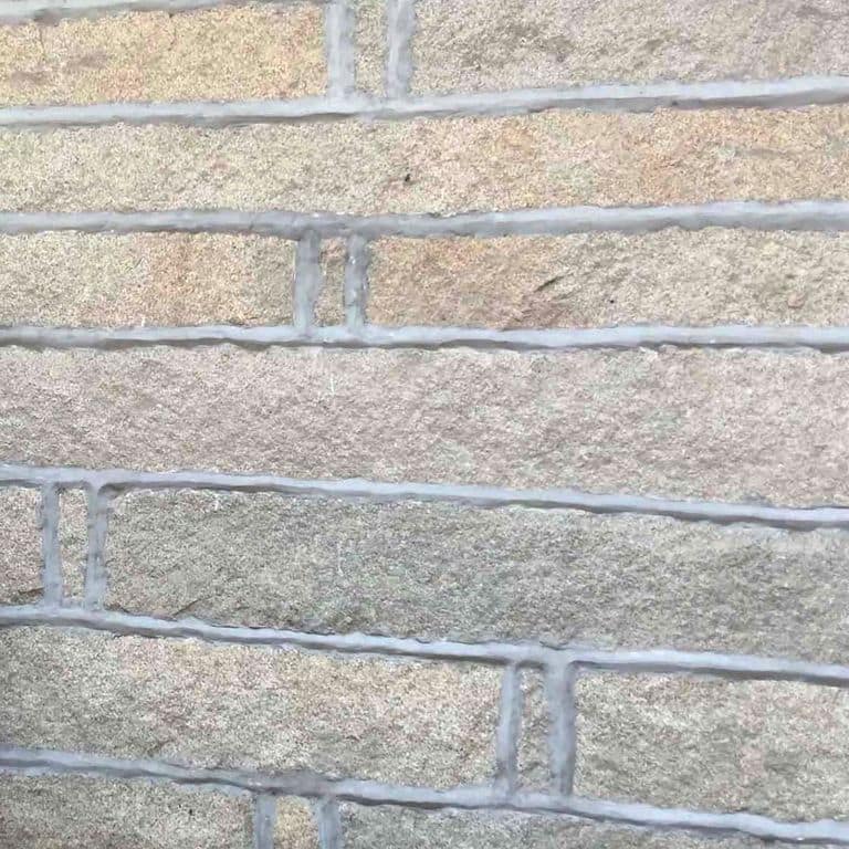 Application image for Reclaimed Granite Plank Veneer. The image shows this product being used in a full bed veneer application. The surface finish shown is . Dominant colors shown are beige and gray. The color mix creates a warm feeling. Regular and fine speckled color patterns.