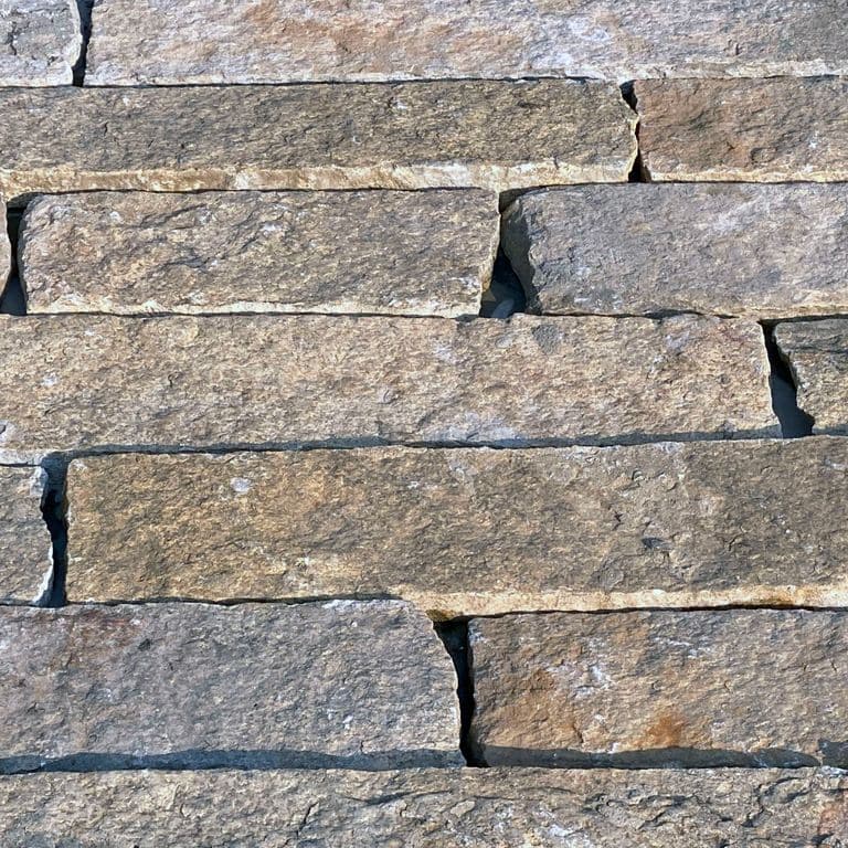 Best close-up image for Reclaimed Rustic Granite - Plank Veneer. The surface finish shown is . Dominant colors shown are beige and gray; with a pink secondary. Regular and fine speckled color patterns.