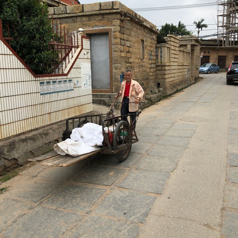 Application image for Granite - Reclaimed Pavers - Squares. The image shows this product being used for driveway pavers and public area. The surface finish shown is . The dominant color shown is gray. The color mix creates a warm feeling. Regular color pattern.