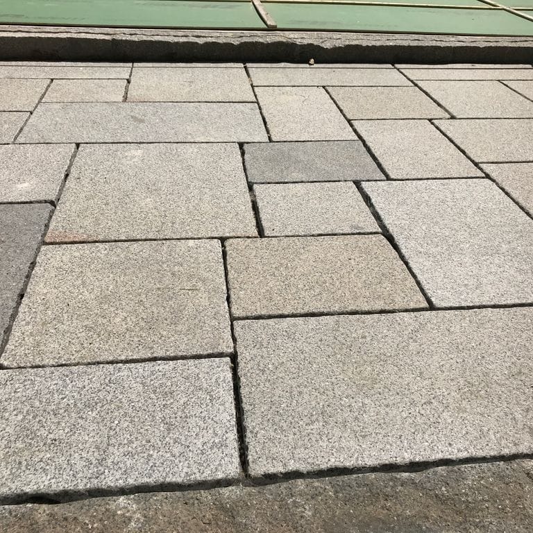 The image shows this product being used in a patio pavers application.