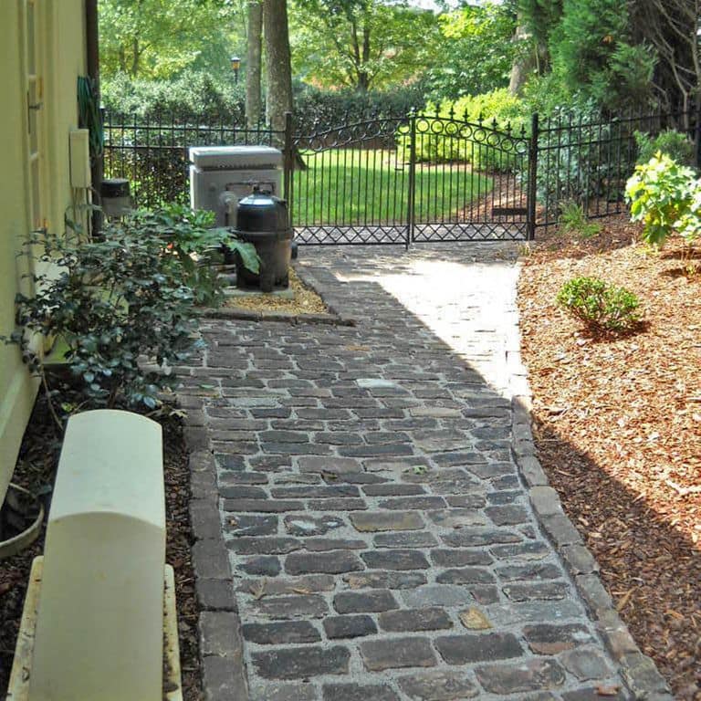 Close-up image for Reclaimed Midwest Medina Sandstone Cobblestones. The surface finishes shown are weathered and worn. The dominant color shown is gray; with brown, orange/rust, purple, white and tan secondaries. Exhibits "movement" and the color mix creates a warm feeling. Random, fine speckled and blotched color patterns.