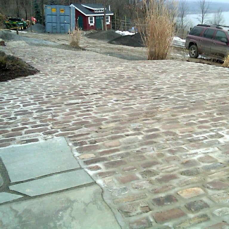 The image shows this product being used in a driveway pavers application.