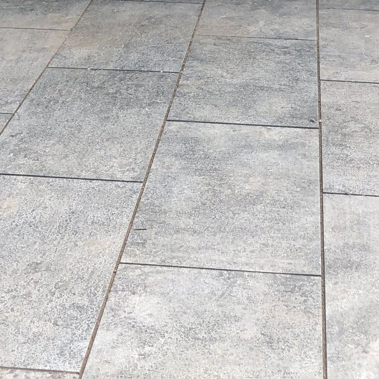 Close-up image for Highland Limestone Dimensional Cut Pavers. The surface finishes shown are brushed and flamed. Dominant colors shown are gray and white; with beige, pink and cream secondaries. Exhibits "movement" and the color mix creates a cool feeling. Speckled, blotched and cloudy color patterns.