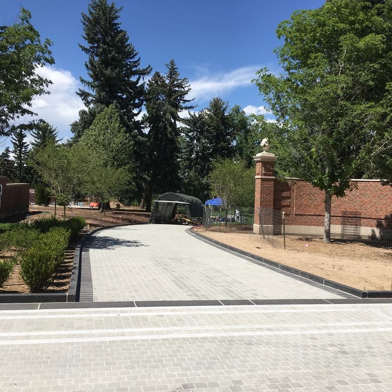 Feature image for Italian Bluestone Pavers. The image shows this product being used for driveway pavers and patio pavers. Dominant colors shown are beige, gray, white and cream. Regular and fine speckled color patterns.