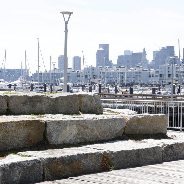 Application image for Reclaimed Granite Bridge Blocks - Benches and Seating. The image shows this product being used for seating &amp; benches and landscape wallstone. The surface finish shown is . The dominant color shown is gray. The color mix creates a cool feeling. Regular color pattern.