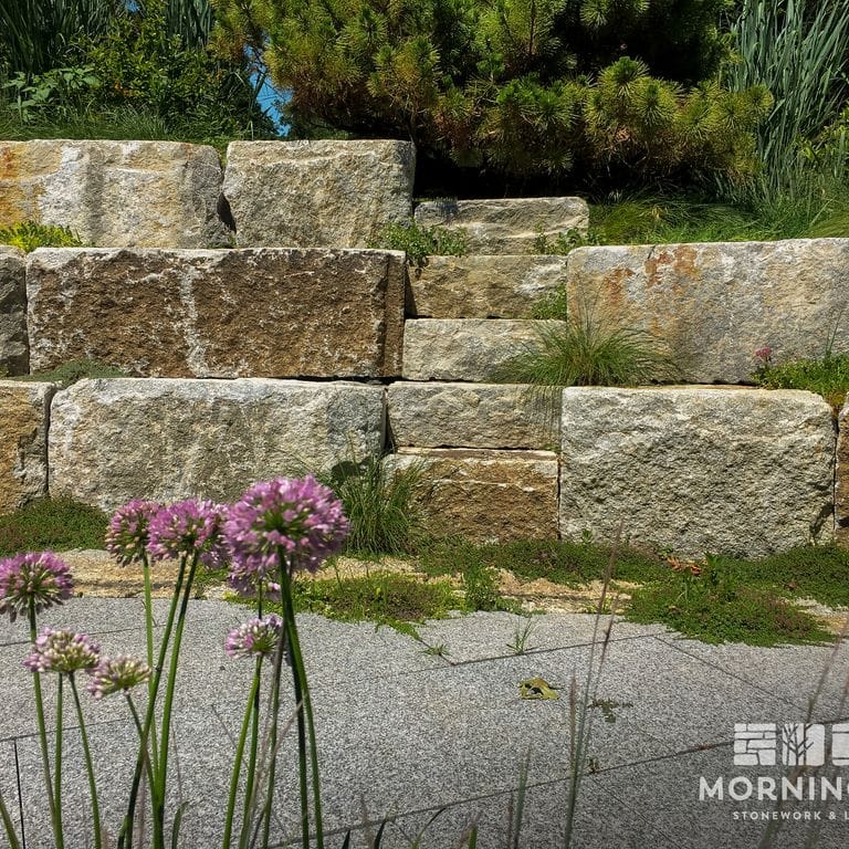 Application image for Reclaimed Granite Bridge Blocks - Benches and Seating. The image shows this product being used in a seating &amp; benches application. This is a landscape stone for outdoor commercial and residential applications. Suitable for general use, freeze-thaw conditions, low heat absorption surfaces and low slipperiness surfaces situations. Relatively higher in price.