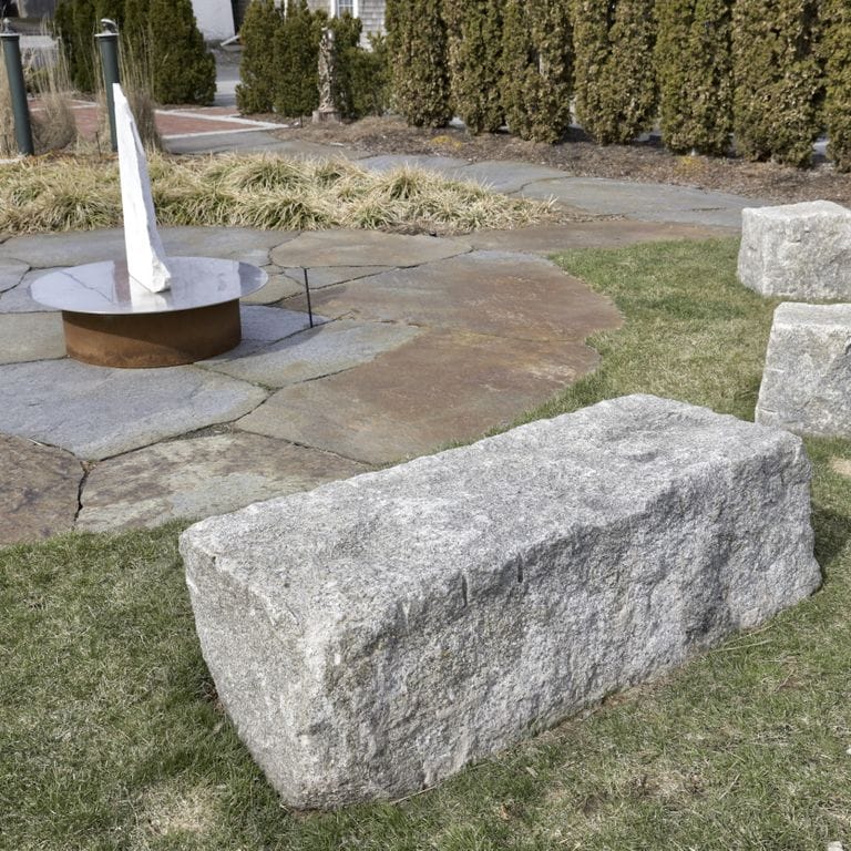 Application image for Reclaimed Granite Bridge Blocks - Benches and Seating. The image shows this product being used in a seating &amp; benches application. This is a landscape stone for outdoor commercial and residential applications. Suitable for general use, freeze-thaw conditions, low heat absorption surfaces and low slipperiness surfaces situations. Relatively higher in price.