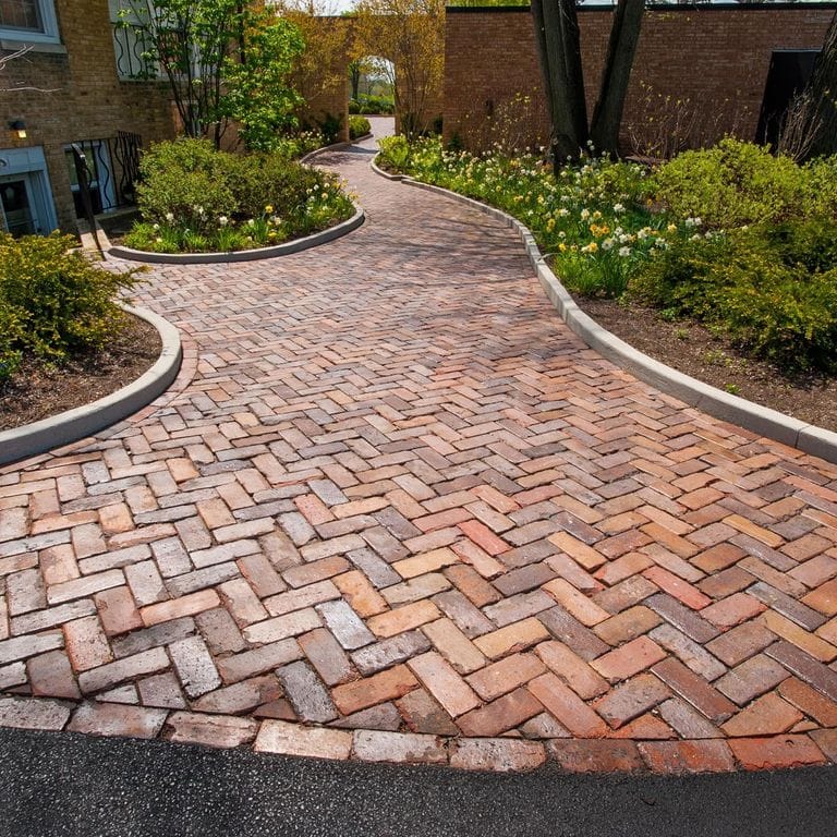 Application image for Brick - Reclaimed Midwest - Pavers. The image shows this product being used in a path pavers application. Dominant colors shown are brown and red. The color mix creates a warm feeling.