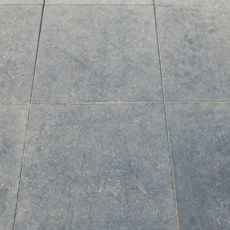 Best close-up image for Belgian Bluestone Pavers. The image shows this product being used in a patio pavers application. Dominant colors shown are blue and gray. The color mix creates a cool feeling. Regular color pattern.