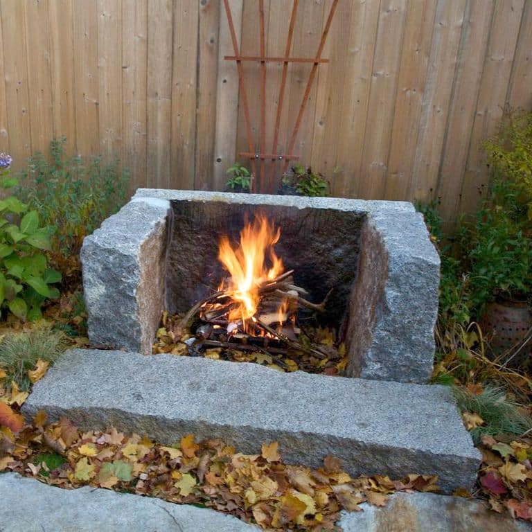 Best close-up image for Reclaimed Granite Fire Feature - Hearth, Mantel, Surround. The image shows this product being used in an outdoor fire concepts application. The surface finish shown is split-face. The dominant color shown is gray. Exhibits "movement" and the color mix creates a cool feeling. Speckled color pattern.
