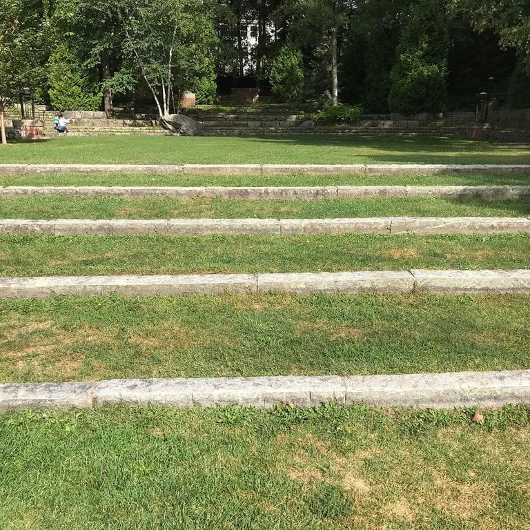 Application image for Reclaimed First Generation Granite Curbstone - Lawn Steps. The image shows this product being used in a monolithic steps application. This is a building and landscape stone for outdoor commercial and residential applications. Suitable for general use, freeze-thaw conditions, low heat absorption surfaces, high traffic areas and low slipperiness surfaces situations. Moderate to higher on the price spectrum.