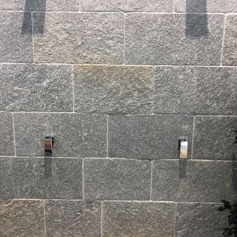 Feature image for Greek Quartzite Slate - Grey - Veneer. The image shows this product being used for full bed veneer and thin veneer. The dominant color shown is gray. Exhibits "movement". Speckled and cloudy color patterns.