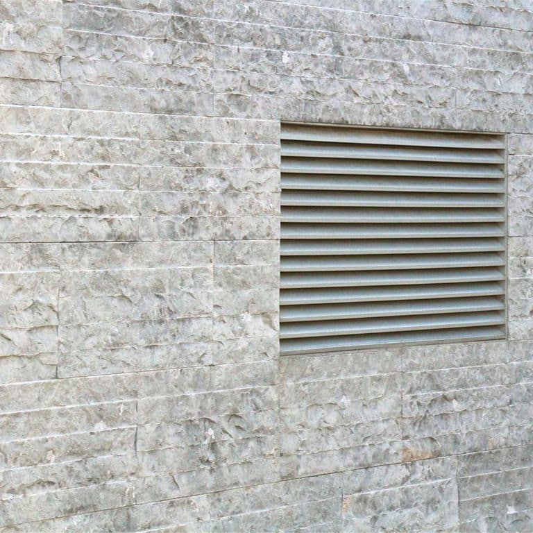 Feature image for Sky Prima Limestone - Veneer. The image shows this product being used for full bed veneer and thin veneer. The dominant color shown is gray; with beige, orange/rust, purple, white and cream secondaries. Exhibits "movement" and the color mix creates a cool feeling. Regular, blotched, linear, swirled and cloudy color patterns.
